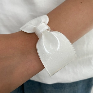 Dettaglio molletta a fiocco bianco perlato in resina con glitter argento scintillanti