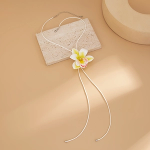 Detailed macro view of orchid pendant with wax cord and adjustable metallic closure
