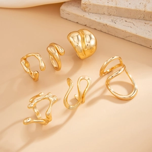 Detail view of six-piece gold ring set featuring irregular liquid lava style and polished finish