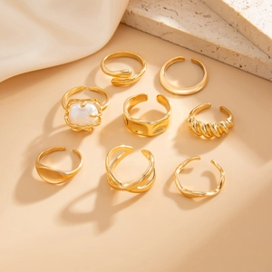 Set of 8 gold minimalist rings including a pearl ring and twisted texture bands