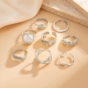 Macro shot of 8-piece silver adjustable rings featuring water drop and pearl details