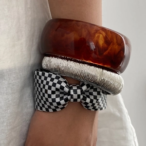 Set chic di bracciali in resina ambrata, righe argentate e fiocco a scacchi neri