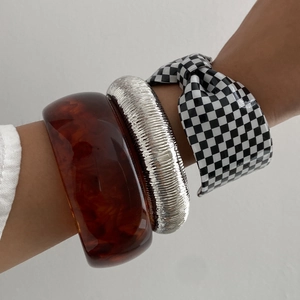 Set di tre bracciali rigidi in resina con motivo a scacchi bianchi e neri e fascia in metallo