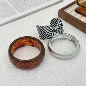 Set di tre pezzi con polsino in resina ambrata, anello in metallo e bracciale a scacchi