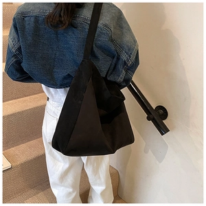 Minimalist large black faux suede tote bag with wide shoulder strap for daily commuting