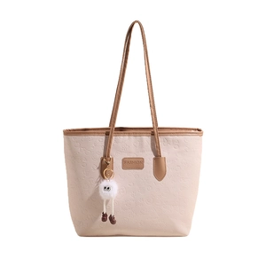 Chic beige tote bag with embossed heart patterns, dark brown straps and plush charm