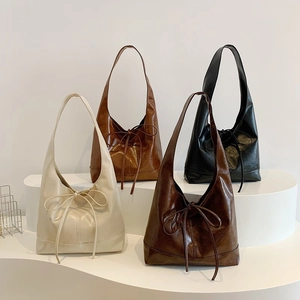 Minimalist faux leather underarm tote bags in four colors with decorative ribbon bows