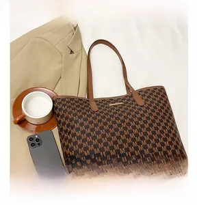 Top view of a large tote bag with M-letter monogram canvas and brown leather straps