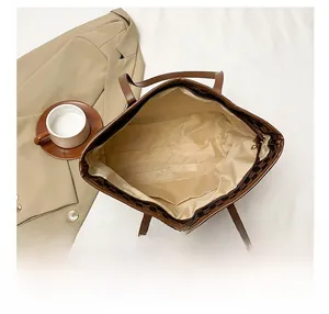 Macro view of spacious tote bag interior showing beige fabric lining and inner pocket