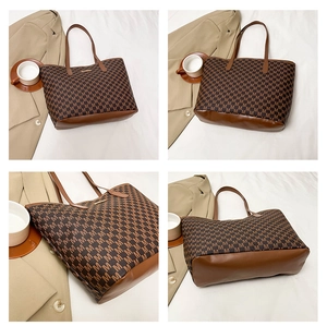 Detail view of large tote bag showing 'M' monogram pattern and brown leather straps