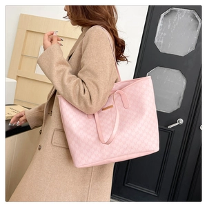 Pink large tote bag with M-letter pattern and gold metal logo shown on a model