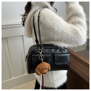 Détail du sac vintage Boston noir avec deux poches frontales et un petit pendentif chien