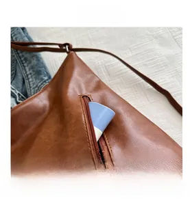 Dettaglio della borsa tote in pelle PU marrone con tasca a zip e spazio interno capiente