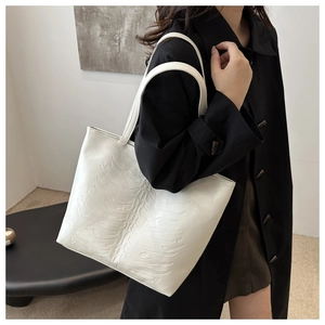 Detail of white tote bag with unique 3D ribcage embossed texture and soft faux leather finish