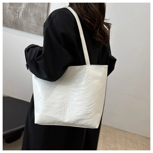 Detail of white tote bag featuring unique 3D rib embossed texture and slim shoulder straps