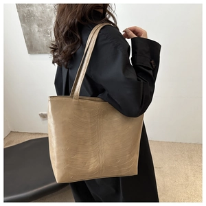 Close-up of khaki tote bag with unique skeleton rib embossing on soft PU leather