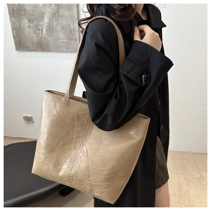 Detail view of khaki tote bag with 3D rib embossing and long straps for shoulder wear