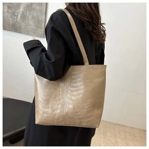 Detail of khaki tote bag with 3D rib bone embossing on matte leather texture
