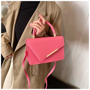 Detail of rose red crossbody bag with lychee texture and gold metal buckle hardware