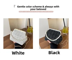 Detail of tweed shell bag with pearl handle and metal chain strap in black and white