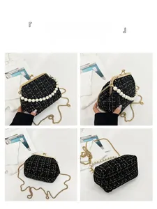 Detail view of black tweed shell bag featuring pearl handle and gold chain strap