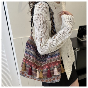 Dettaglio borsa tote bohémien con motivi etnici e nappe colorate stile vintage