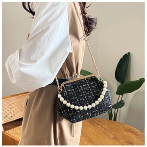 Detail of vintage black tweed crossbody bag with pearl handle and golden chain strap