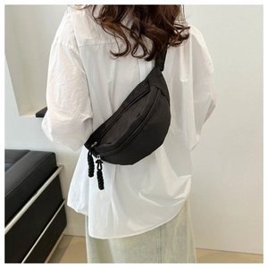 Détail de la sacoche de poitrine noire minimaliste avec cordon de fermeture tissé
