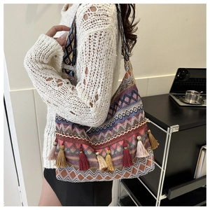 Dettaglio della borsa tote boho intrecciata con nappe colorate e motivi etnici geometrici