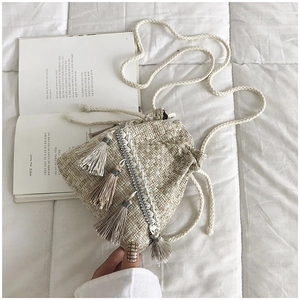 Dettaglio della borsa a secchiello in tweed con paillettes e nappa stile boho