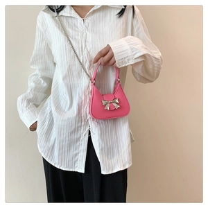 Vue détaillée d'un mini sac rose avec un nœud en métal argenté et une bandoulière