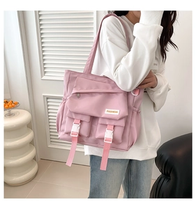Détail du sac cabas rose en nylon avec multiples poches et inscription fashion
