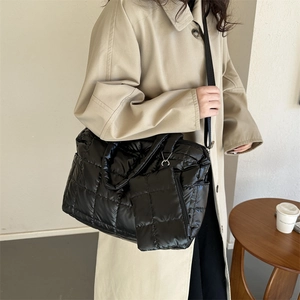 Détail du sac cabas matelassé noir avec porte-monnaie assorti et bandoulière réglable