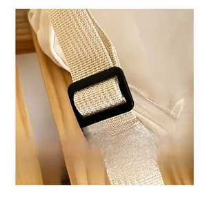 Dettaglio della tracolla intrecciata beige regolabile con fibbia nera della borsa a stella