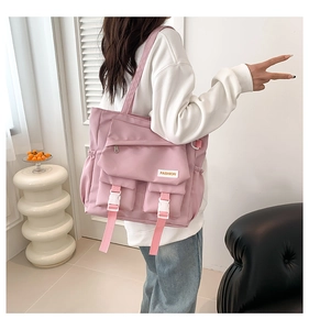 Vue détaillée du grand sac fourre-tout rose en nylon avec poches et boucles réglables