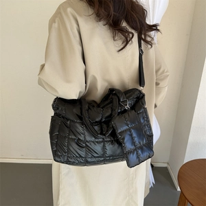 Détail d'un cabas matelassé noir avec petit porte-monnaie et bandoulière réglable