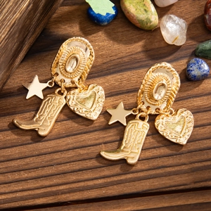 Detail of gold western cowboy earrings with star, textured boot, and embossed heart charms