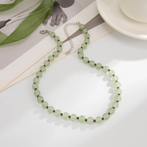 Detail van doorschijnende groene kralenketting met donkere spacers en verstelbare sluiting