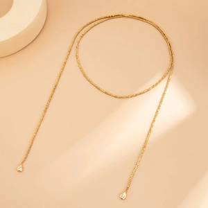 Dettaglio della collana a Y dorata con perline quadrate e pendenti a goccia lucidi