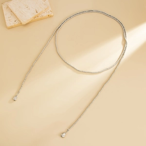 Dettaglio della collana a Y con perline d'argento, pendenti a goccia lucidi e consistenza