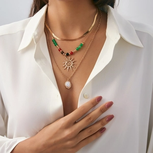 Three-layer bohemian gold necklace with sun pendant, colorful beads, and baroque pearl