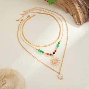 Three-layer gold necklace with snake chain, sun pendant, colorful beads and pearl