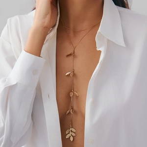 Elegante collana a Y dorata con delicati ciondoli a foglia su una catena sottile da donna