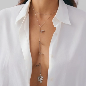 Elegante collana lunga a Y in argento con delicati ciondoli a foglia su una modella