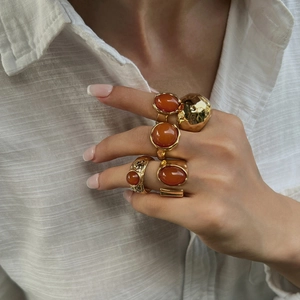 Vintage gold alloy ring set with amber resin and geometric patterns worn by a model