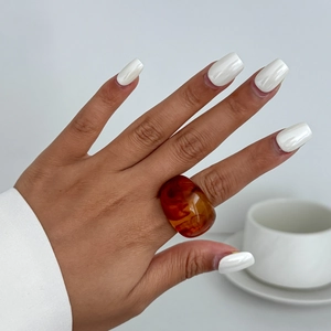 Detailansicht eines bernsteinfarbenen Harzrings mit minimalistischem Design am Modell
