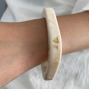 Elegante bracciale in resina geometrica con motivo tartarugato crema indossato al polso