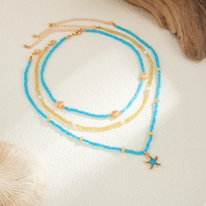 Dettaglio della collana da spiaggia a strati con perline blu, conchiglie e ciondolo stella