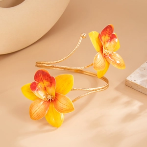 Detail van een gouden dubbellaagse armband met kleurverloop van orchideebloemdecoratie