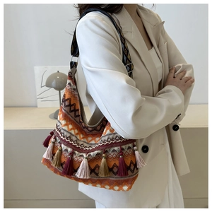 Dettaglio della borsa boho con nappe colorate e texture geometriche intrecciate